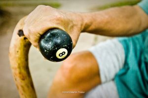 hand on cane with an 8 ball on the handle